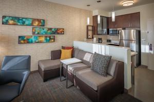 a living room with a couch and chairs and a kitchen at Residence Inn by Marriott Dallas at The Canyon in Dallas
