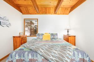 a bedroom with a bed and wooden ceilings and a window at Snowbird Chalet #5 in Girdwood