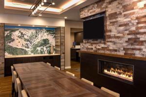 Residence Inn by Marriott Wenatchee في ويناتشي: غرفة طعام مع موقد وتلفزيون
