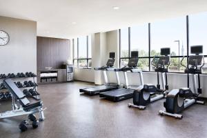 a gym with several treadmills and a clock at AC by Marriott Hotel Huntsville Downtown in Huntsville