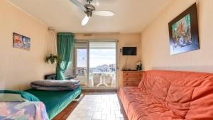 uma sala de estar com um sofá e uma varanda em Les Indes Galantes- 72 - Studio vue mer - 6 pers em Cap d'Agde