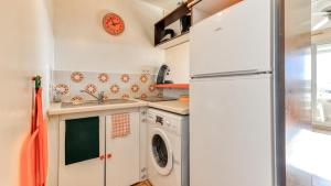 uma cozinha com um frigorífico e uma máquina de lavar e secar roupa em Les Indes Galantes- 72 - Studio vue mer - 6 pers em Cap d'Agde