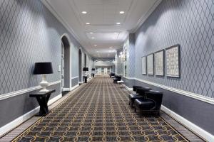 a hallway with black chairs and a hallway with blue walls at Sheraton Charlotte Hotel in Charlotte