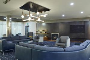 a lobby with couches and a tv and a fireplace at Courtyard Medford Airport in Medford