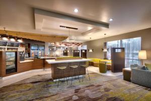 een grote keuken met een bar en een woonkamer bij Courtyard by Marriott Charlotte Airport/Billy Graham Parkway in Charlotte