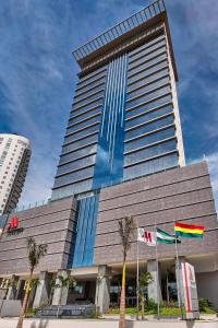 un edificio alto con dos banderas delante en Marriott Santa Cruz de la Sierra Hotel, en Santa Cruz de la Sierra