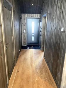 um corredor vazio com uma porta e um piso de madeira em Cosy apartment with ski in/out em Noresund