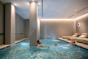 2 personnes se baignant dans une piscine d'un hôtel dans l'établissement Myrion Beach Resort & Spa - Adults Only, à Gerani