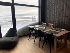 a table and chairs in a room with a large window at Cosy apartment with ski in/out in Noresund