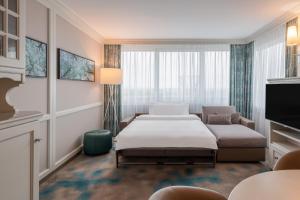 a hotel room with a bed and a couch at The Westin Grand Munich in Munich