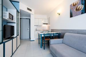 een woonkamer met een bank en een tafel bij Aparthotel Imperial in Bibione