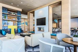 eine Lobby mit Tischen und Stühlen und einem TV in der Unterkunft Residence Inn by Marriott Dallas Frisco in Frisco