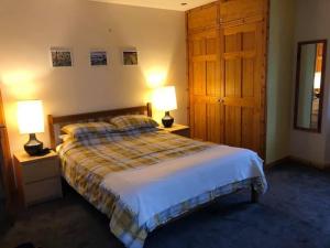 1 dormitorio con 1 cama y 2 mesitas de noche con lámparas en Stay Kirkwall Apartments - Ayre Road, en Kirkwall