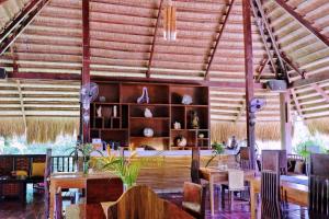 a dining room with tables and chairs in a building at Lio Villas Resort in El Nido