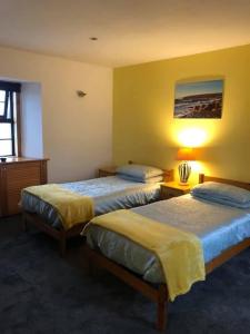 una habitación de hotel con 2 camas y una lámpara en Stay Kirkwall Apartments - Ayre Road en Kirkwall