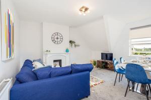 um sofá azul numa sala de estar com uma mesa em Beautiful newly refurbished apartment close to the promenade. em Llandudno