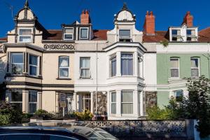 a large house with a car parked in front of it at Beautiful newly refurbished apartment close to the promenade. in Llandudno