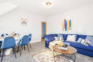 uma sala de estar com um sofá azul e uma mesa em Beautiful newly refurbished apartment close to the promenade. em Llandudno