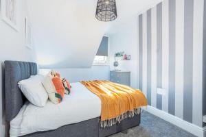 um quarto com uma cama com um cobertor em Beautiful newly refurbished apartment close to the promenade. em Llandudno