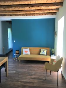 Hôtel Le Cassini في Le Freney-dʼOisans: غرفة معيشة مع أريكة والجدار الأزرق