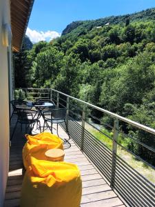 - un balcon avec des couvertures jaunes, une table et des chaises dans l'établissement Hôtel Le Cassini, à Le Freney-dʼOisans