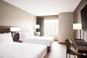 a hotel room with two beds and a desk at AC Hotel by Marriott Atlanta Perimeter in Atlanta +41 photos