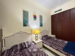 a bedroom with two beds and a lamp on a night stand at Dubai Backpackers in Dubai