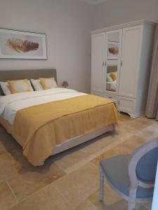 een slaapkamer met een groot bed en een gele deken bij Palazzo Pisani Malta B&B in Żabbar