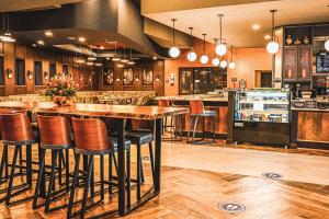 a large kitchen with a bar with stools at Delta Hotels by Marriott Cincinnati Sharonville in Sharonville
