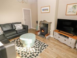 a living room with a couch and a fireplace at Sandtop in Tenby