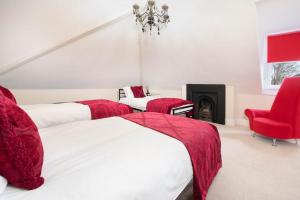 a bedroom with three beds and a red chair at Bath View Apartments in Bath