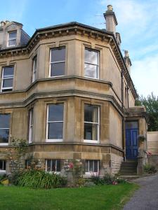 an old brick house with a blue door and windows at Bath View Apartments in Bath