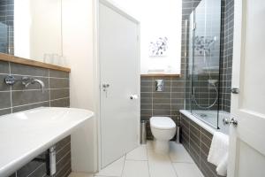 a bathroom with a sink and a toilet and a shower at Bath View Apartments in Bath