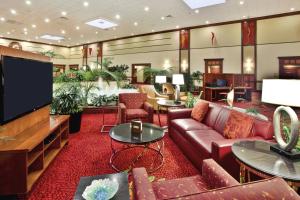 a lobby with a couch and a flat screen tv at Columbus Airport Marriott in Columbus