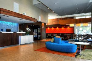 Fairfield Inn & Suites by Marriott Los Angeles Rosemead في روسيميد: لوبي وكرسي ازرق وطاولة