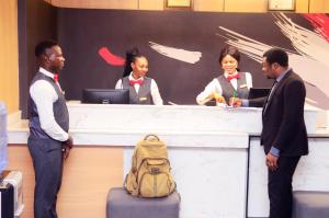 a group of people standing at a desk at Ivy Hotel Emerald in Ikeja