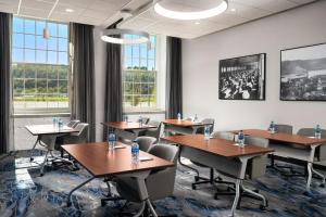 a conference room with tables and chairs and windows at Fairfield Inn & Suites Madison Historic Eagle Cotton Mill in Madison