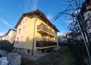 a house under construction with the sun shining on it at Банско Апартментс in Bansko