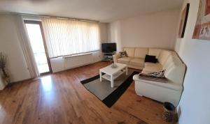 a living room with a couch and a table at Банско Апартментс in Bansko