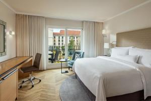 a hotel room with a large bed and a desk at The Westin Grand Berlin in Berlin