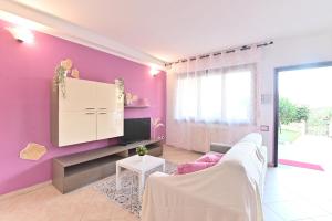 a living room with a purple wall at IzzHome Njoy in Pula