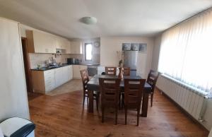 a kitchen and dining room with a table and chairs at Банско Апартментс in Bansko
