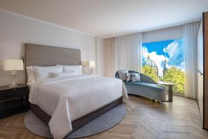 a bedroom with a large bed and a large window at The Westin Grand Berlin in Berlin