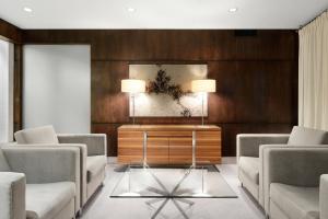 a living room with two chairs and a table with two lamps at Sheraton Cavalier Saskatoon Hotel in Saskatoon