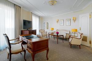 a room with a desk and chairs and a television at The Westin Grand Berlin in Berlin
