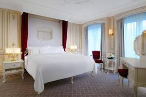 a bedroom with a large white bed and a desk at The Westin Grand Berlin in Berlin