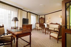 a living room with a table and chairs and a television at The Westin Grand Berlin in Berlin