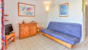 a bedroom with a blue bed and a tv at Archipel- 5B- Appart loggia - 4 pers in Cap d'Agde