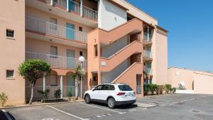 a car parked in a parking lot in front of a building at Archipel- 5B- Appart loggia - 4 pers in Cap d'Agde