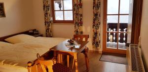 1 dormitorio con mesa, cama y ventana en Haus Brandstein Ferienwohnungen en Ramsau